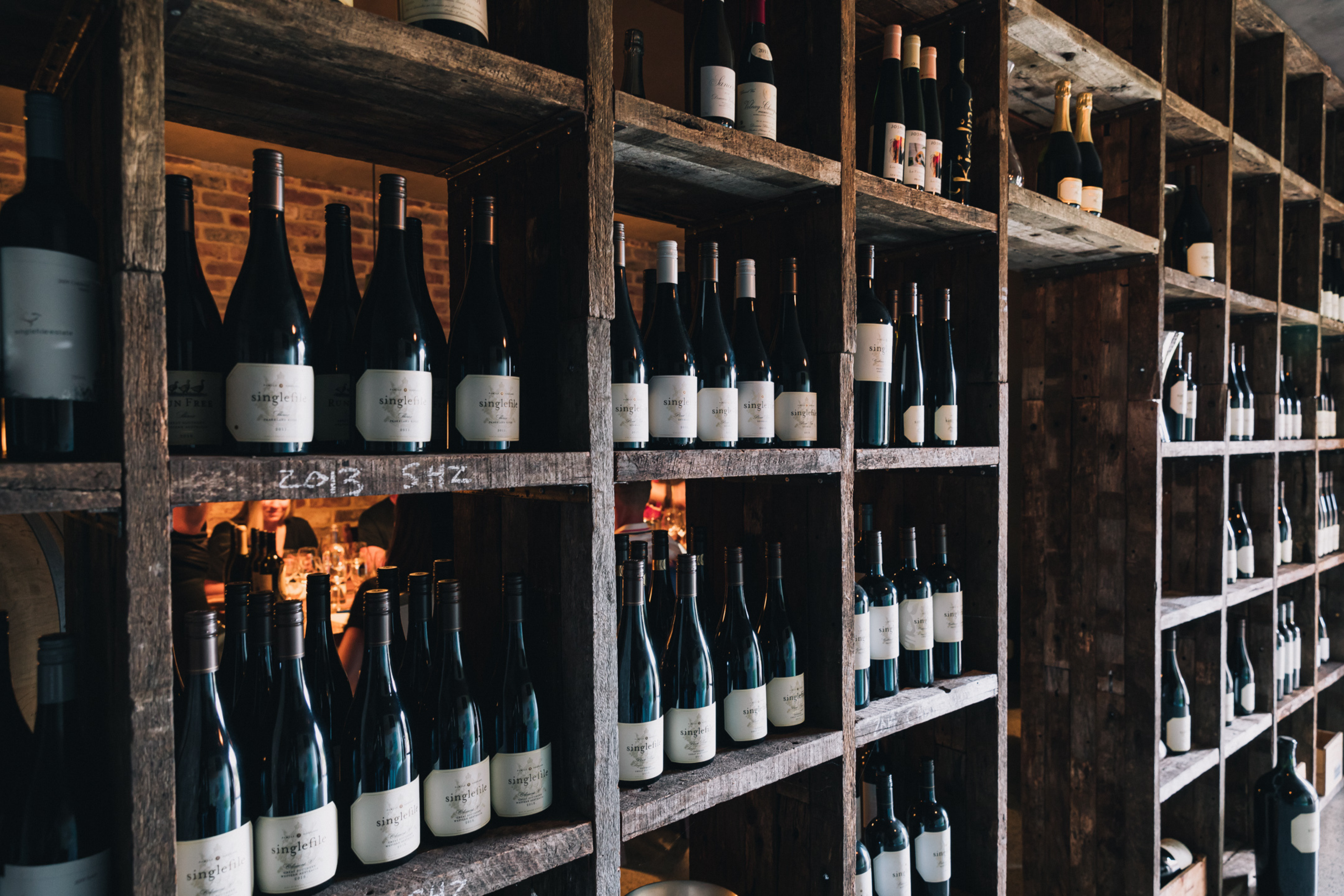 Shelves filled with wine bottles in a dimly lit room