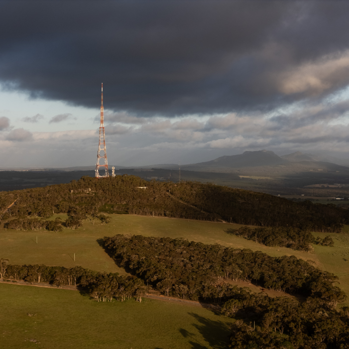 Radio tower on a hill with a stormy sky