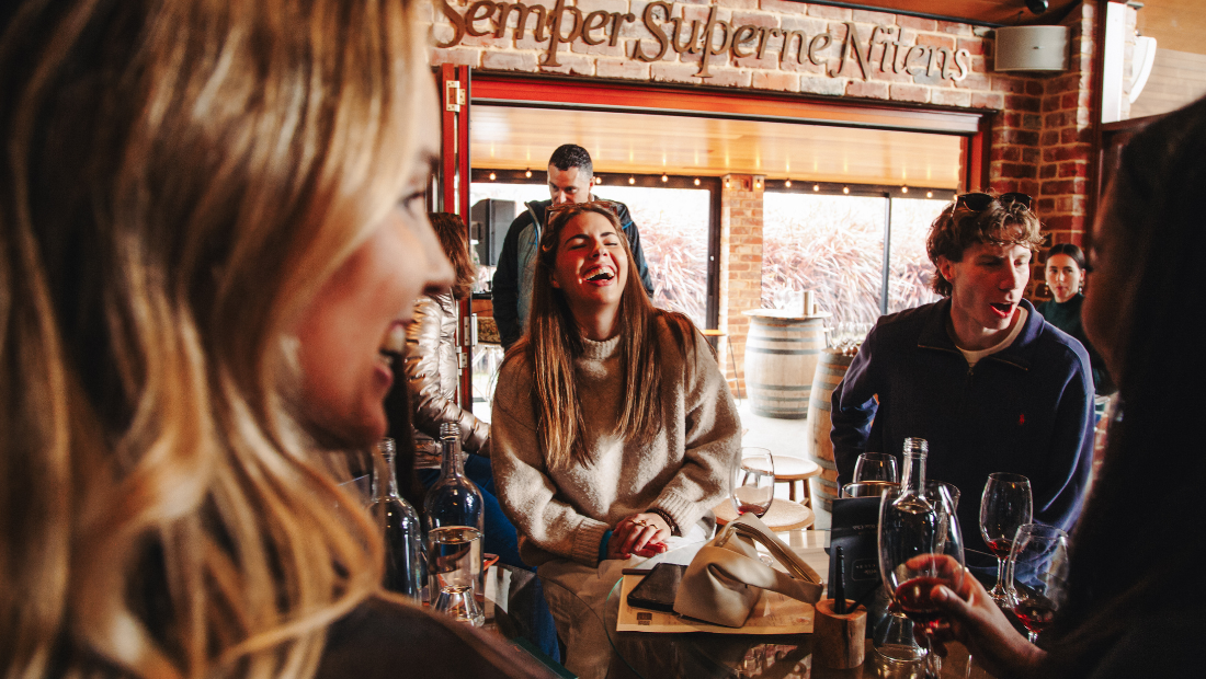 People sitting at a table in a restaurant with a sign above them.