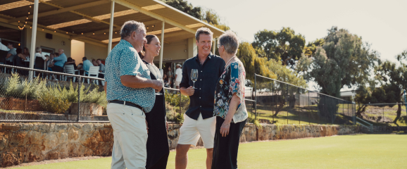 Group of people on a golf course with a clubhouse in the background