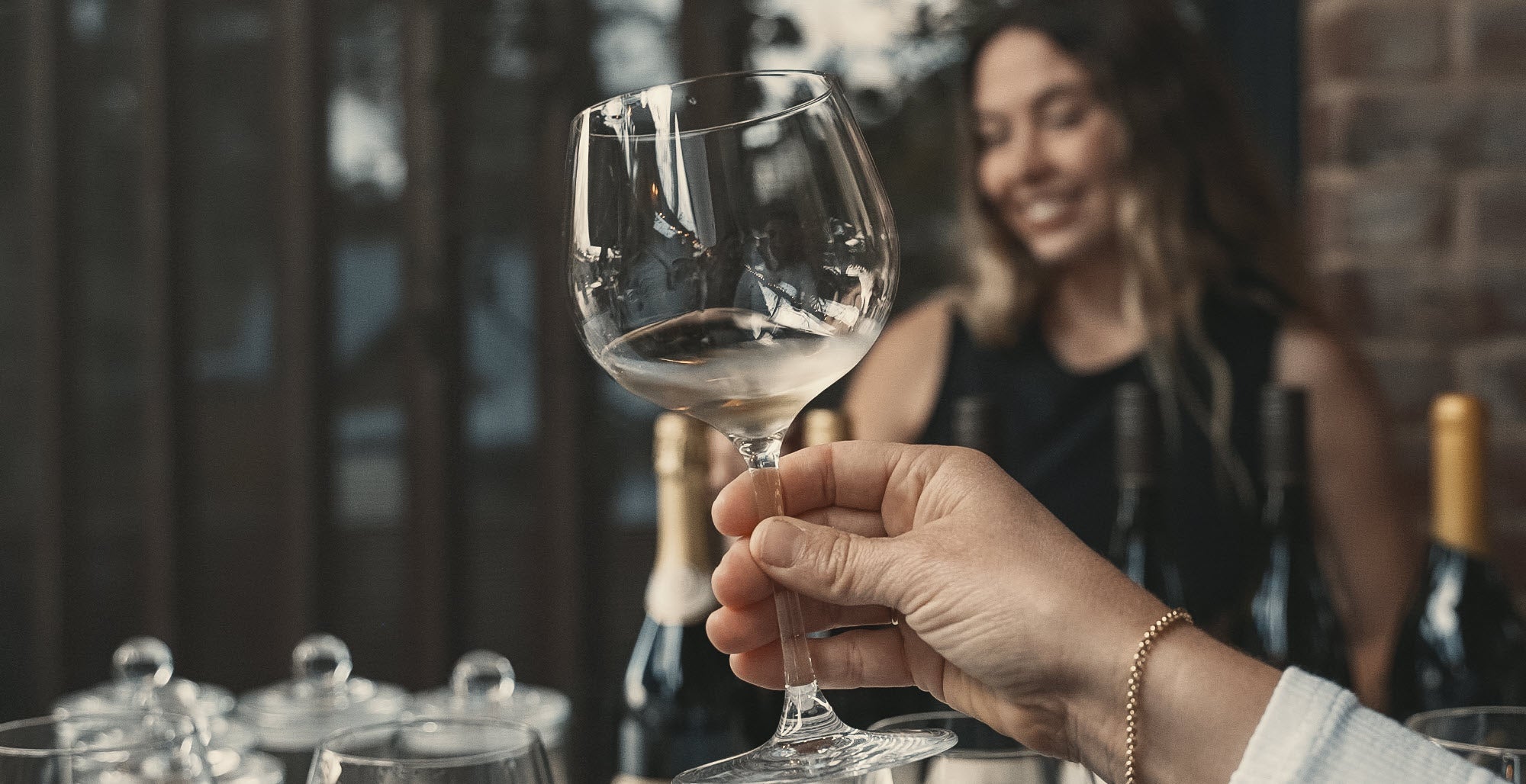 A hand holding up a glass of Chardonnay