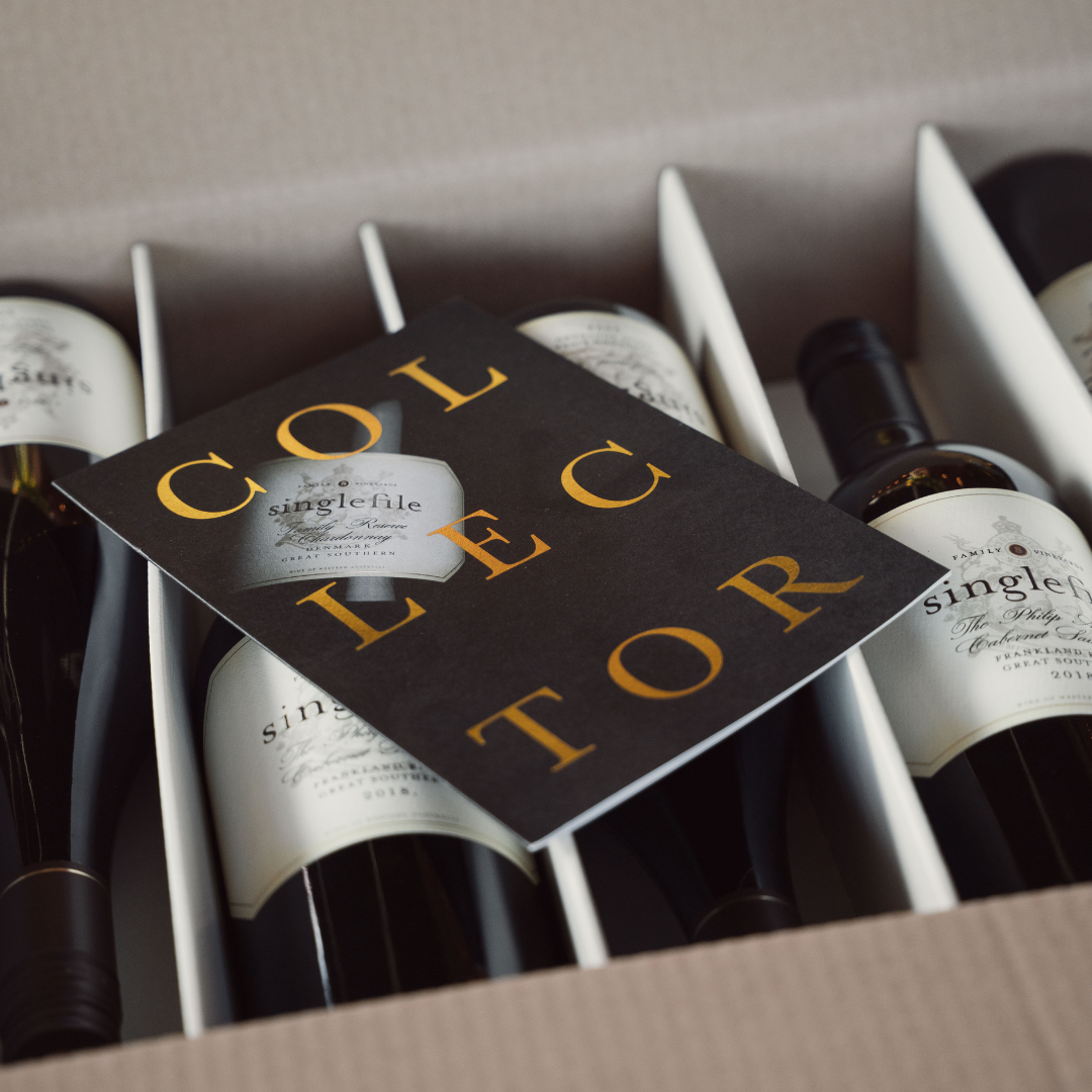 Wine bottles in a box with a 'Collector' card on top