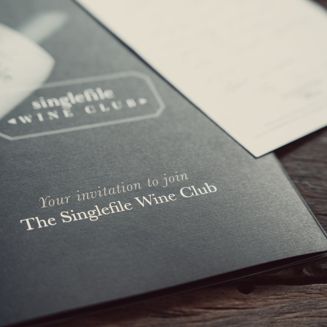 Invitation card to join The Singlefile Wine Club on a wooden surface