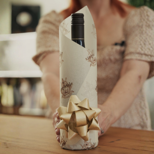 Wine wrapped in paper with a bow