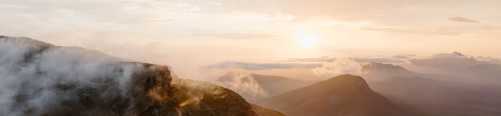 Sunrise over misty mountains with a warm glow