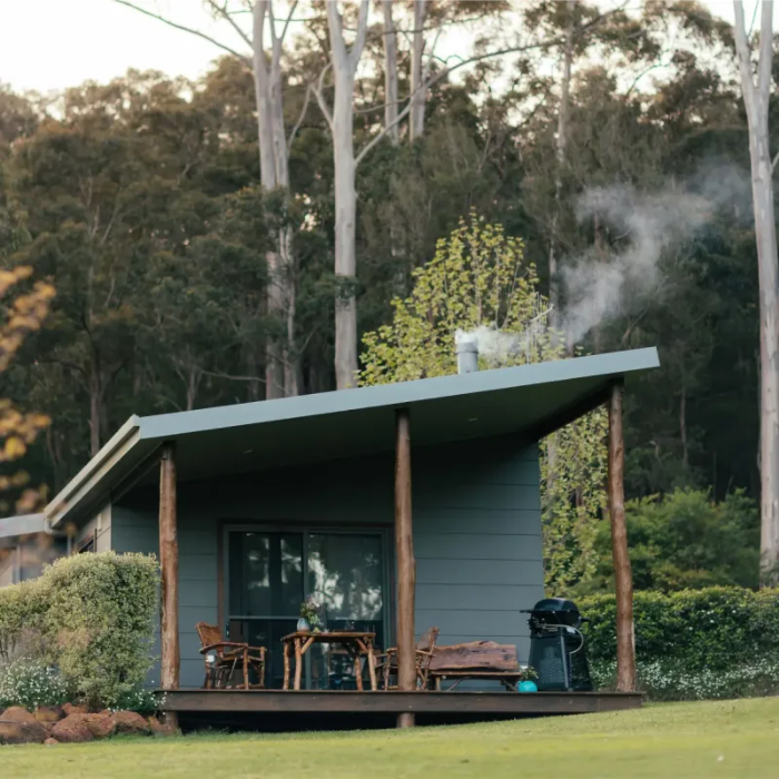 Cabin in a forest with a deck and outdoor furniture